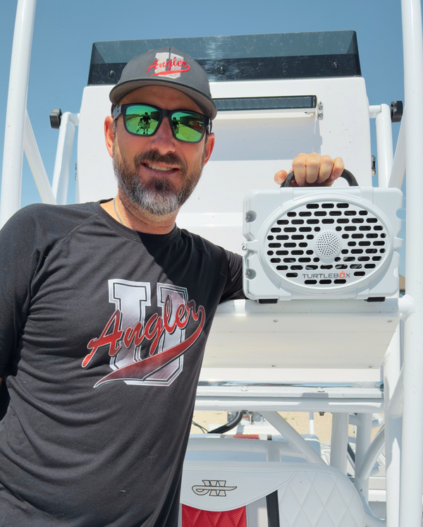 Caleb McCumber with his White Original Turtlebox on his boat