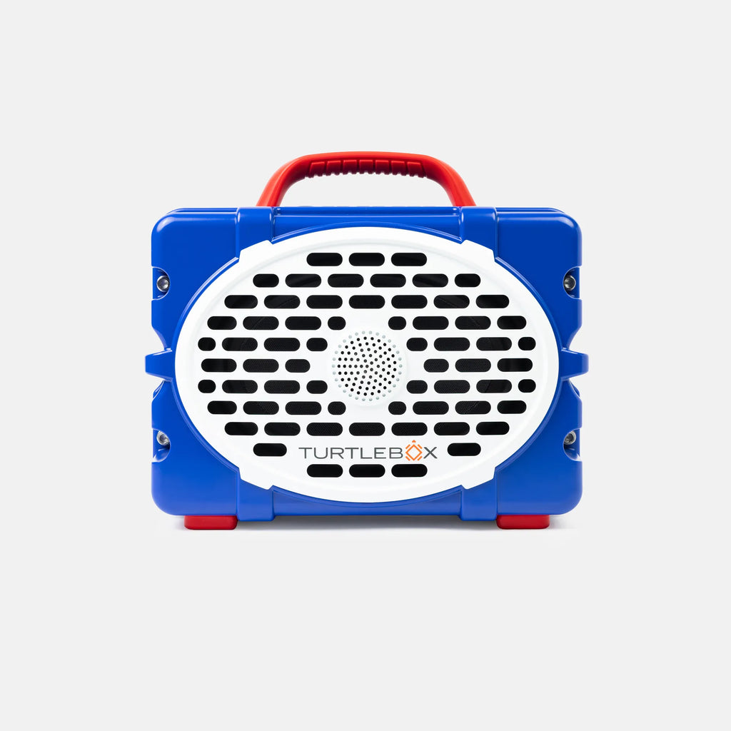 A blue and white portable speaker with a red handle, branded TURTLEBOX, shown against a light gray background.