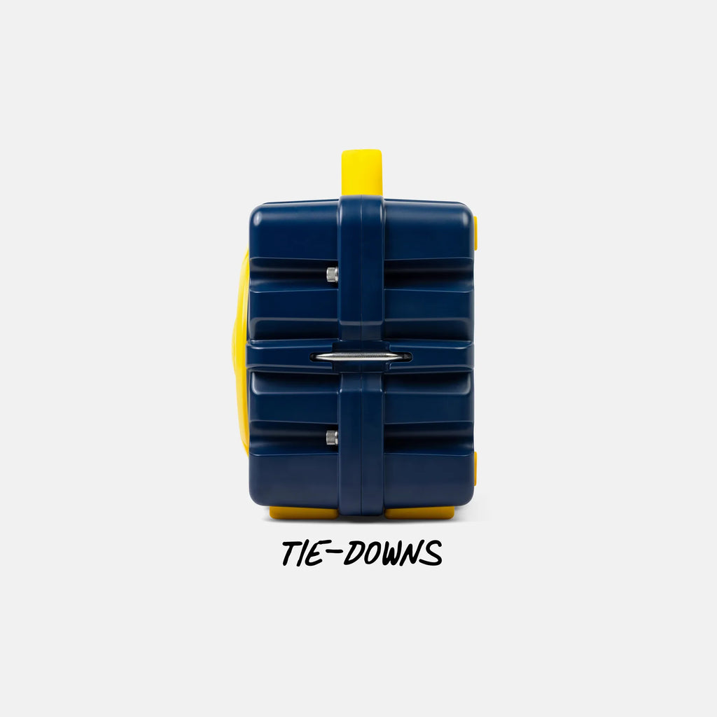 A dark blue and yellow hard-shell luggage-style case shown from the back on a light gray background, with the text 'TIE-DOWNS' below it.