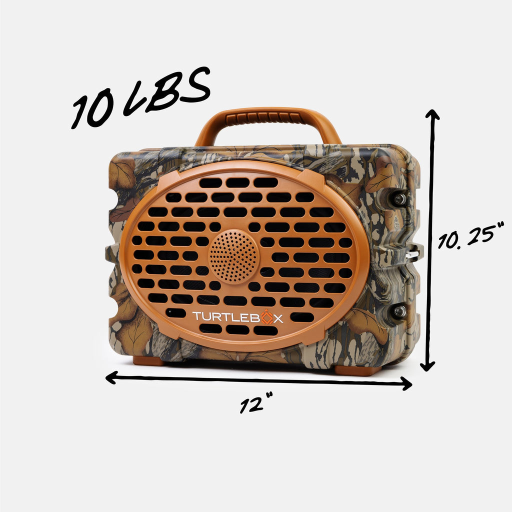 A camouflage-patterned portable speaker with a brown handle and front grille, shown with black dimension arrows and text indicating 12 inches wide, 10.25 inches tall, and 10 lbs.