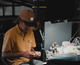 Lifestyle photo of a man at a work table wearing the Jean Bill Roughware Flat Brim Hat