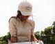 Lifestyle photo of a woman holding a fish, wearing the Rip-Stop Rainbow Tarpon Hat
