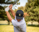 Lifestyle photo of a man swinging his golf club, wearing the Jammin' Turtle Trucker hat