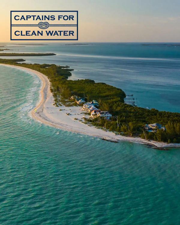 Drone shot of beautiful ocean with land in the middle dotted with houses and docks and the Captains for Clean Water logo.