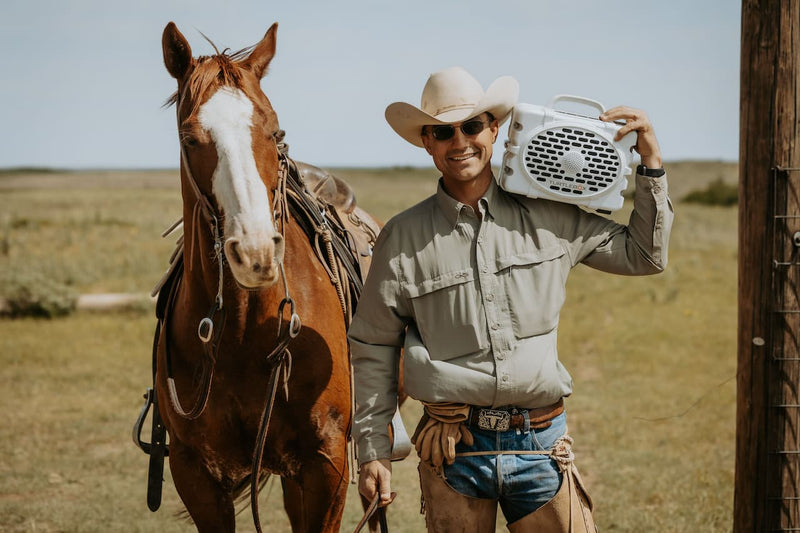 Dusty Burson carrying a Turtlebox besides his horse.