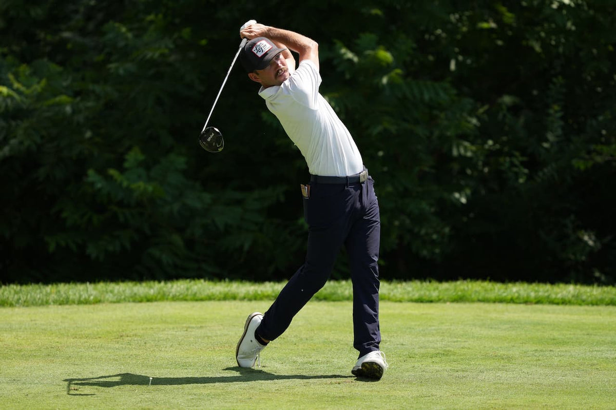 lifestyle photo of a man golfing, wearing a Live Free Patch Blue Hat