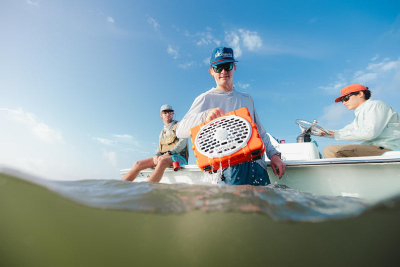 Guys with boat removing orange speaker from water