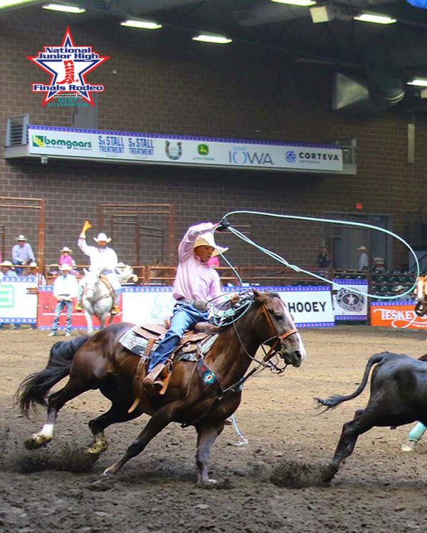 Cowgirl roping a steer at a rodeo showcasing the National Junior High Finals Rodeo logo.
