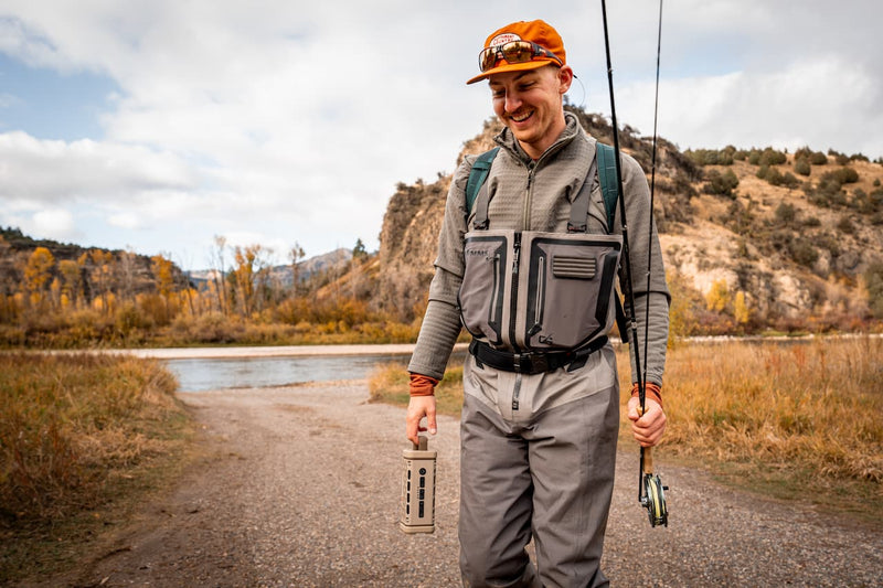 Guy with a orange hat going to fish with a Turtlebox Ranger speaker in tan color