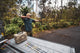 A lifestyle photo of a man shooting a bow with a tan Turtlebox on the back of his truck #speaker-color_tan