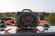 lifestyle photo of a green turtlebox strapped to a vehicle with orange Turtlebox straps