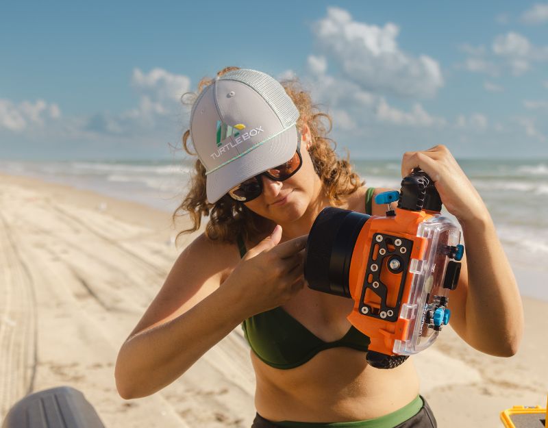 Lifestyle photo of a woman on the beach wearing the Turtle Mountain Gray Hat