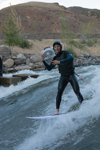 Miles Harvey surfing with Turtlebox speaker on his shoulder.