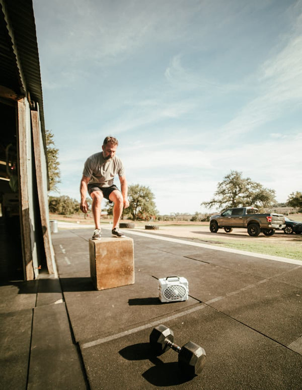 A guy doing a workout with a box and a Original speaker playing music
