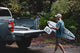 A lifestyle photo of Shane Dorian putting the white Original speaker on the back of a truck with a surfboard on his arm #speaker-color_white