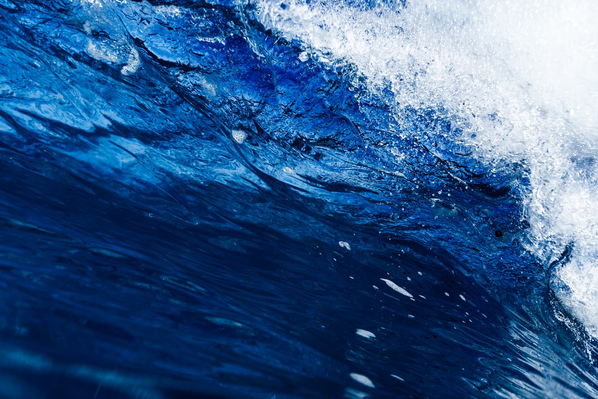 Close-up of a blue ocean wave with white foam