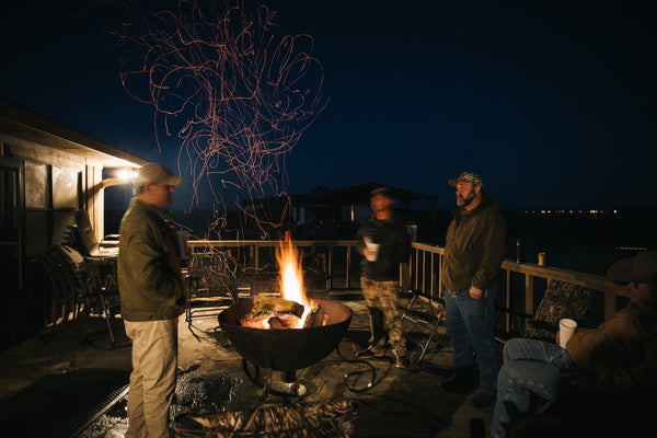 Group of people gathered around a fire pit at night