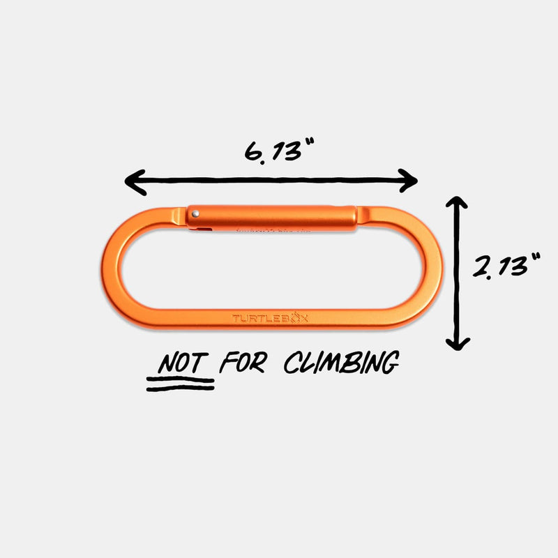 An orange metal carabiner shown on a light gray background with black dimension arrows and text indicating 6.13 inches wide by 2.