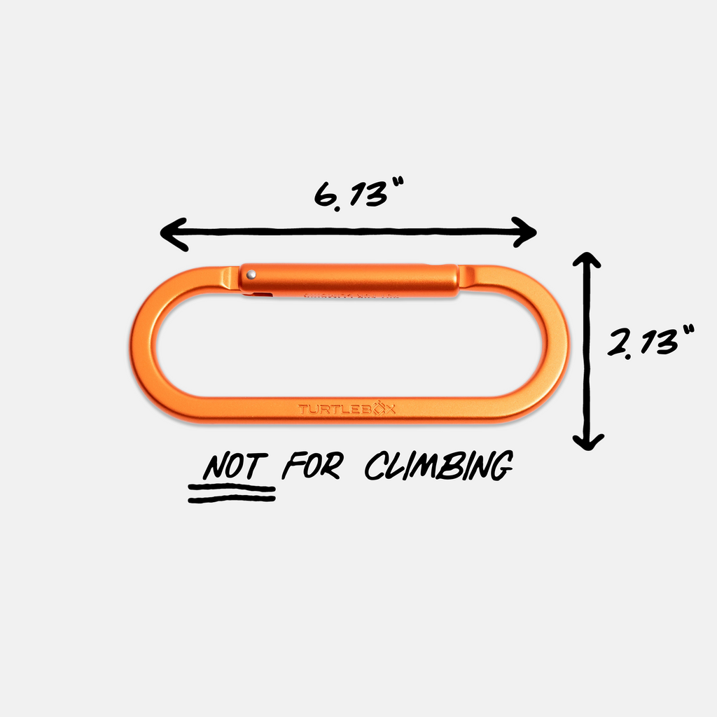 An orange metal carabiner shown on a light gray background with black dimension arrows and text indicating 6.13 inches wide by 2.
