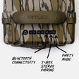 Close-up of the top control panel of a camouflage-patterned Turtlebox speaker, showing the power, volume, Bluetooth, pairing, and party mode buttons with handwritten callouts.