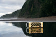 A lifestyle photo of a Fighting Lady Yellow Turtlebox Ranger speaker on a reflective water surface with a mountainous background #base-color_fighting-lady-yellow