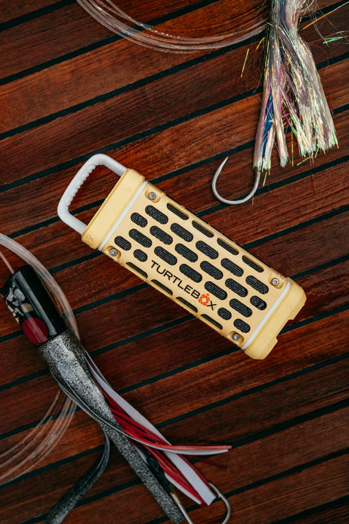 Turtlebox device on a wooden surface with fishing equipment