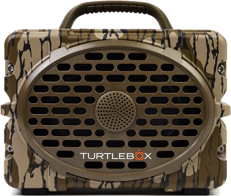 A rugged portable speaker by Turtlebox with a camouflage pattern in tan, brown, and black, featuring a large oval front grille and a top carrying handle.