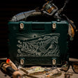 A lifestyle photo of the Bass Artist Series speaker with fish design and fishing gear on a dark background #base-color_bass-artist-series