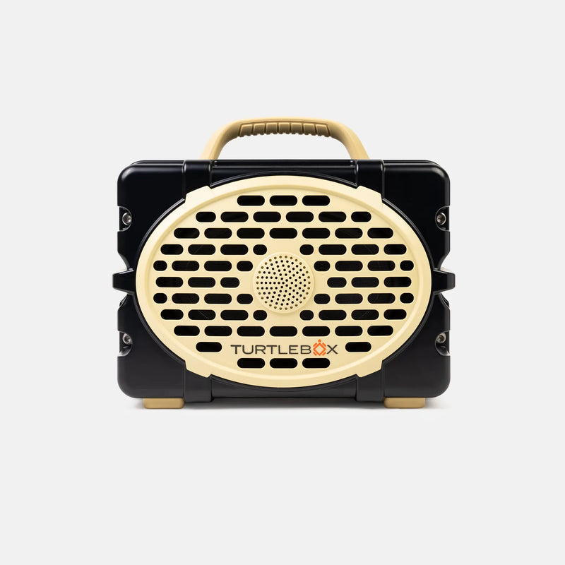 A portable Turtlebox speaker in a black and beige color scheme, shown from the front against a light gray background.