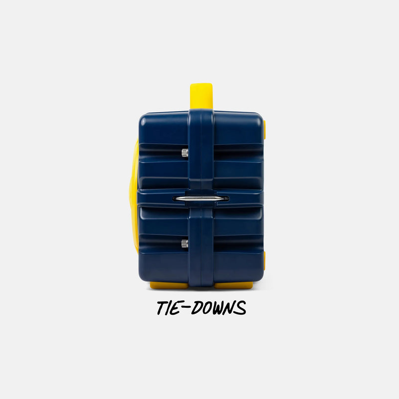 A dark blue and yellow hard-shell luggage-style case shown from the back on a light gray background, with the text 'TIE-DOWNS' below it.