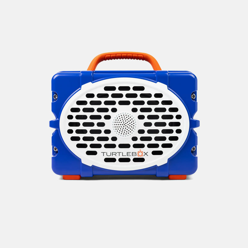 A blue and white portable speaker with an orange handle, branded TURTLEBOX, shown against a light gray background.