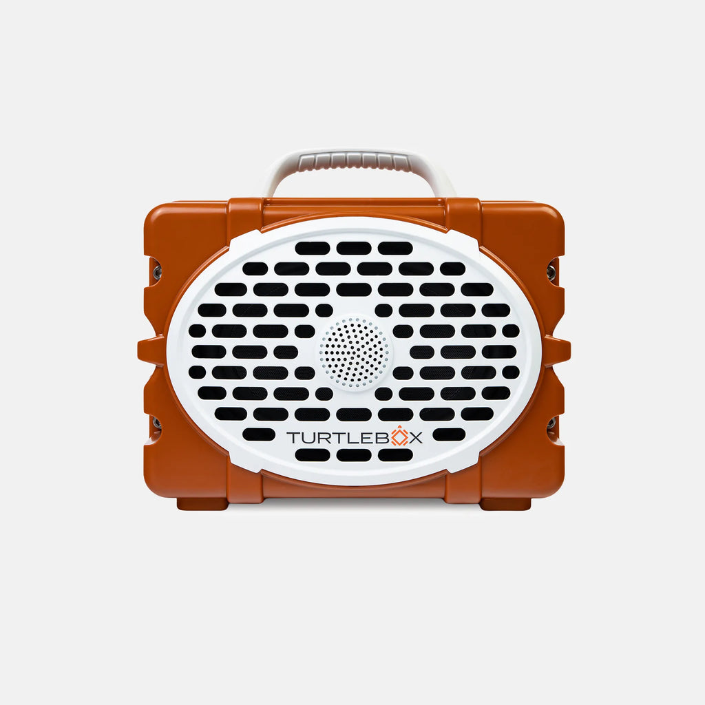 An orange and white TurtleBox portable speaker with a carrying handle, shown against a light gray background.