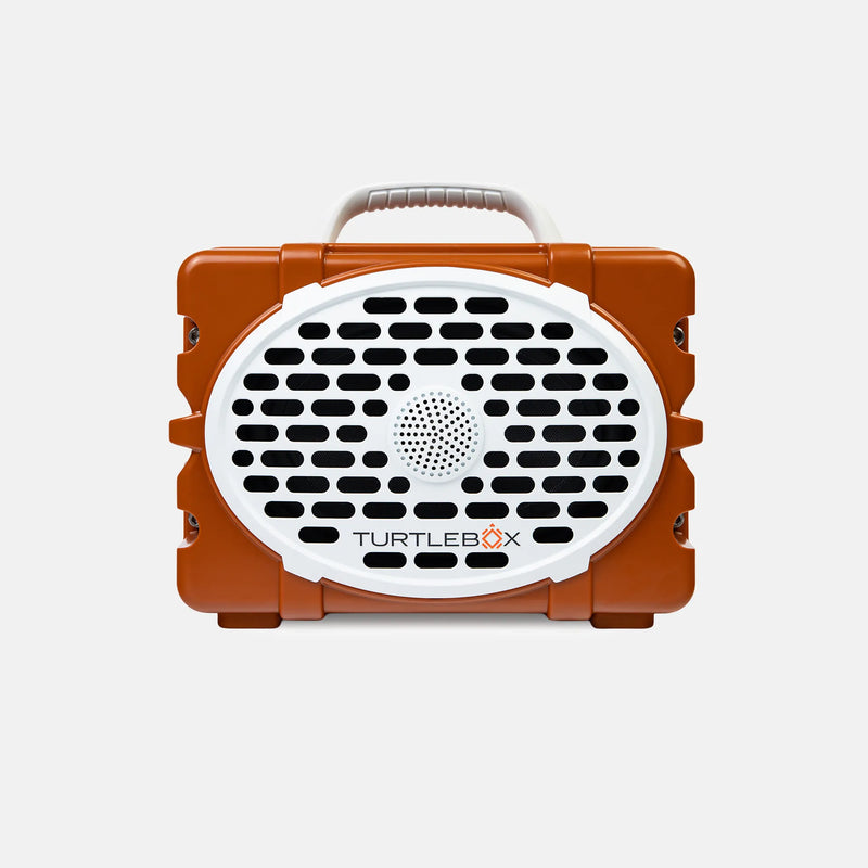 An orange and white TurtleBox portable speaker with a carrying handle, shown against a light gray background.