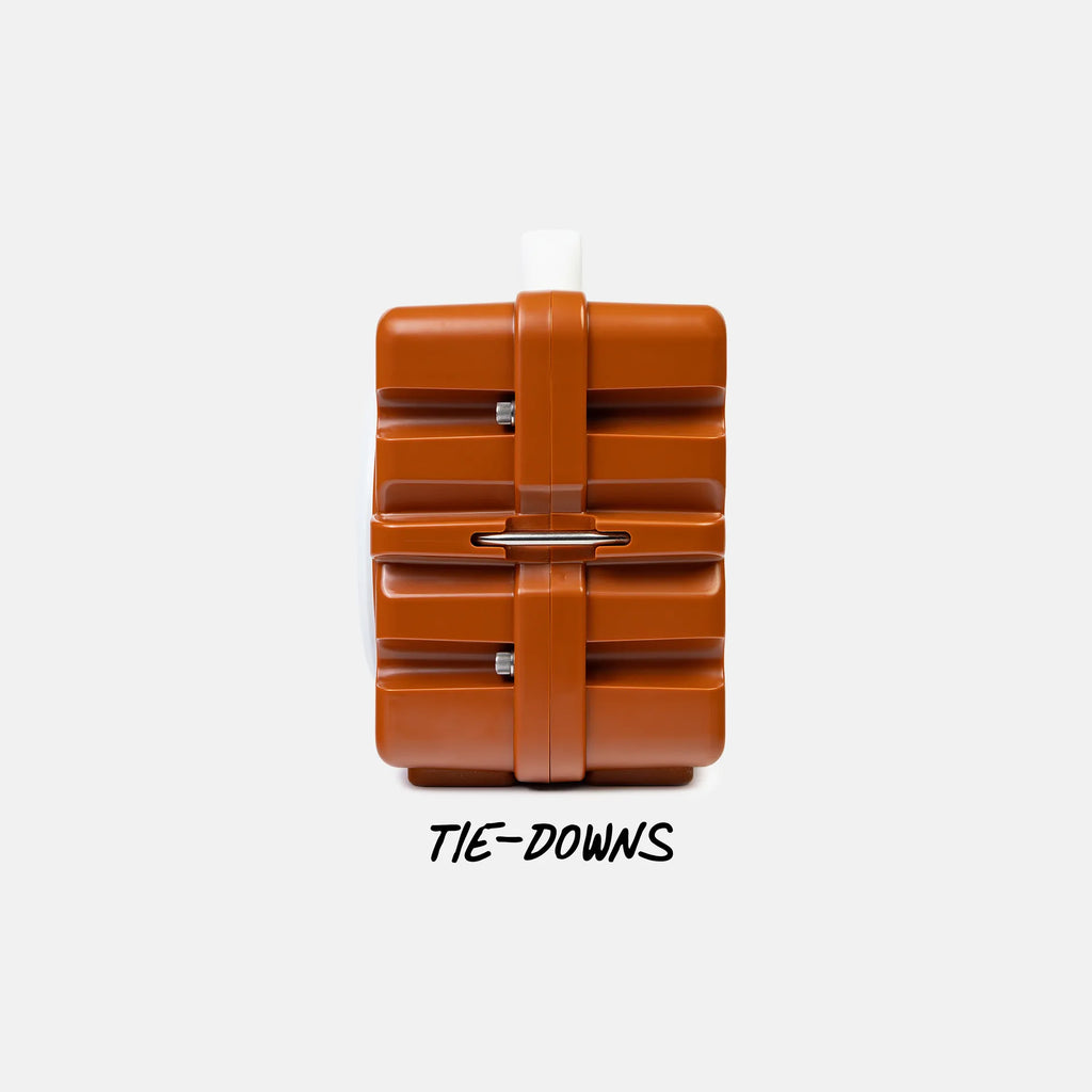 A brown plastic tie-down bag with a central strap and metal D-ring, shown against a light gray background with the text 'TIE-DOWNS' underneath.