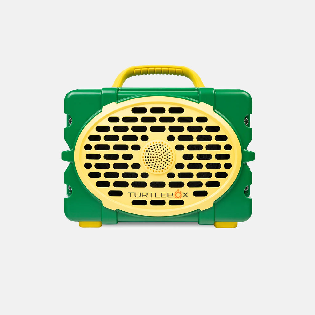 A green and yellow portable speaker case by TurtleBox, featuring a yellow handle, yellow front grille, and black speaker grilles, shown against a light gray background.