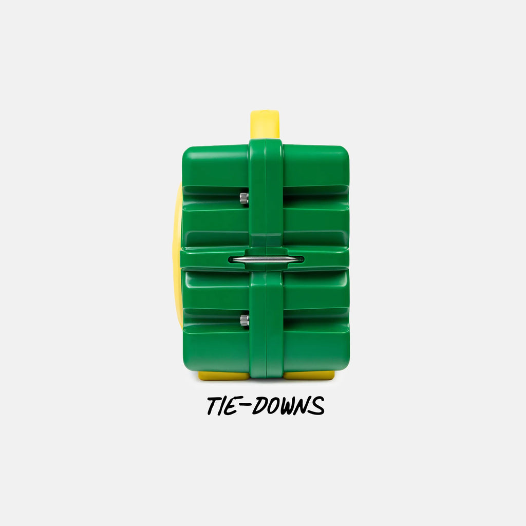 A green and yellow plastic tie-down restraint device with a metal bar across the center, shown on a light gray background with the text 'TIE-DOWNS' underneath.