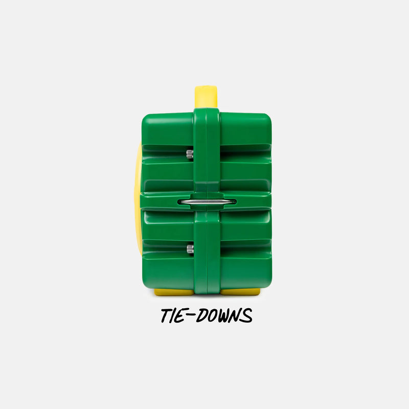 A green and yellow plastic tie-down restraint device with a metal bar across the center, shown on a light gray background with the text 'TIE-DOWNS' underneath.