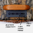 Close-up of a TURTLEBOX electronic control panel mounted on camouflage-patterned packaging or a case, with black arrows and labels pointing to Bluetooth connectivity, 2-box stereo pairing, and party mode controls.