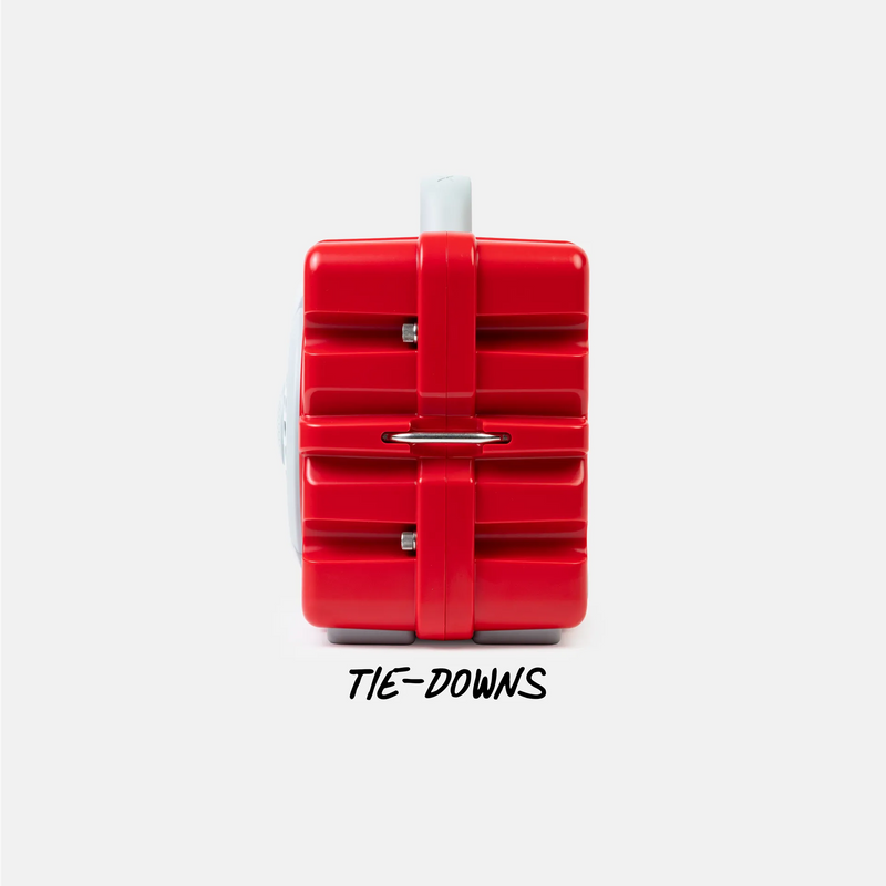 A red plastic tie-down strap or restraint accessory with a white plastic end, shown from the side against a light gray background, with the text 'TIE-DOWNS' printed below.