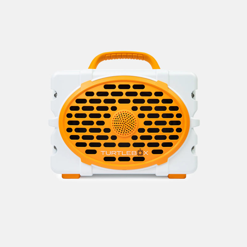 A portable Turtlebox speaker in white and bright orange, featuring a large oval front grille with the brand name printed on it, set against a clean light gray background.