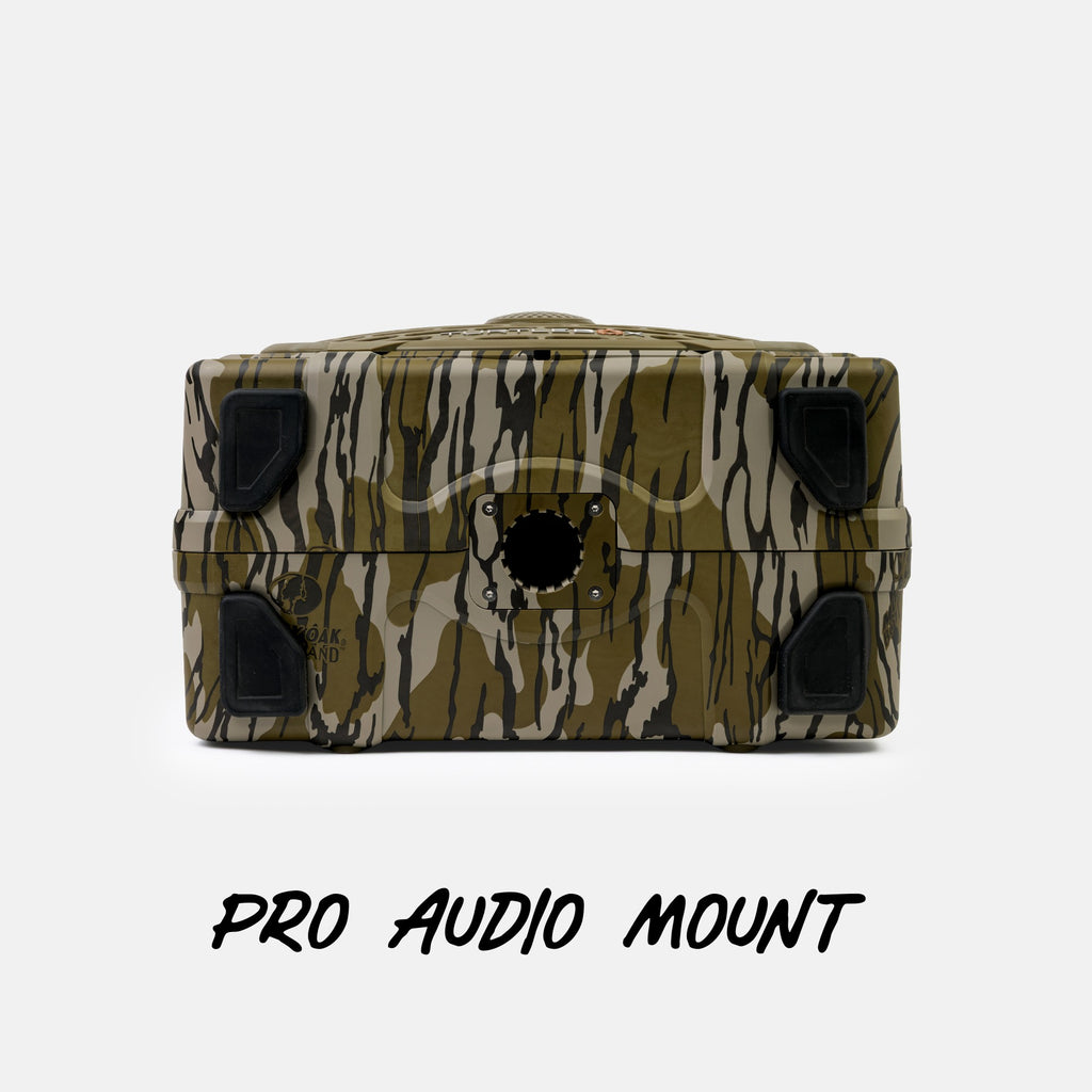 A rugged rectangular audio mount with a green, brown, and beige tiger-stripe camouflage pattern and black rubber feet, shown against a light gray background with the text 'PRO AUDIO MOUNT' below.