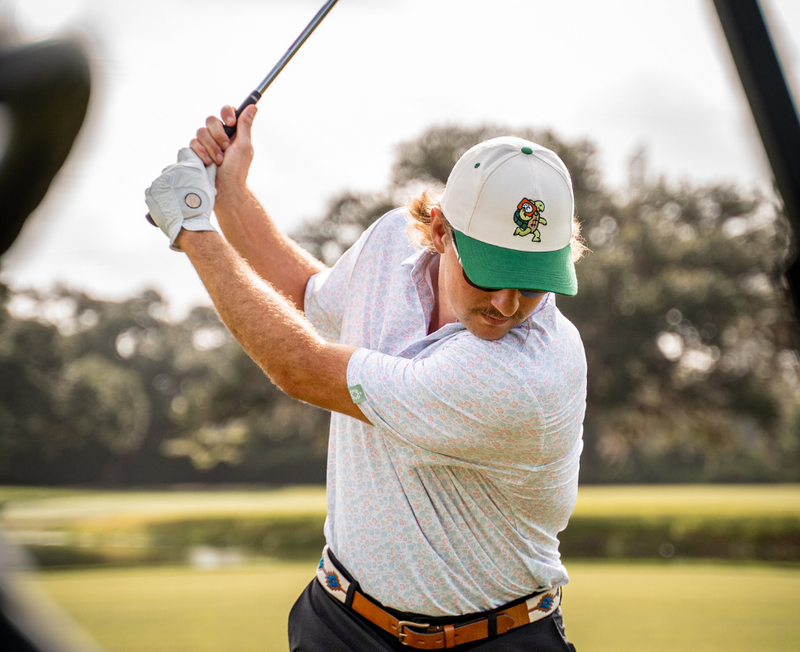 Lifestyle photo showing a man swinging is golf club wearing a Jammin' Turtle Cap 