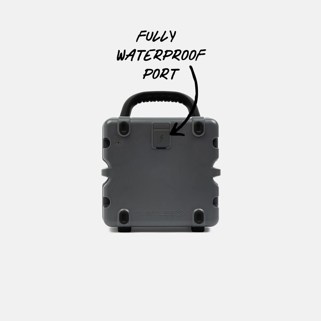 Gray waterproof portable speaker with text indicating a fully waterproof port on a white background #base-color_gray