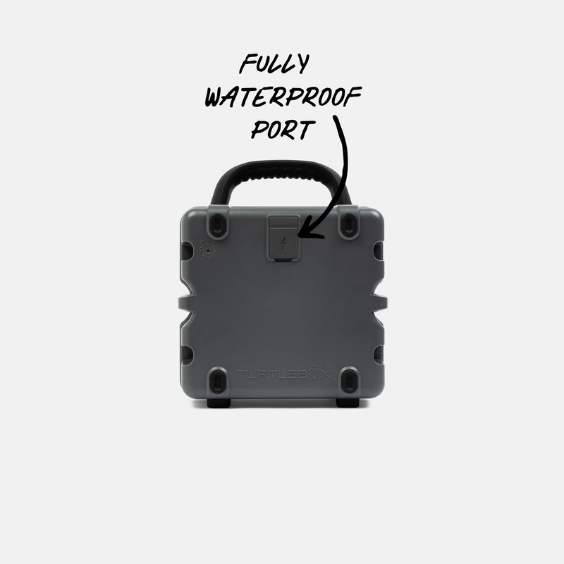 Gray waterproof portable speaker with text indicating a fully waterproof port on a white background #base-color_gray