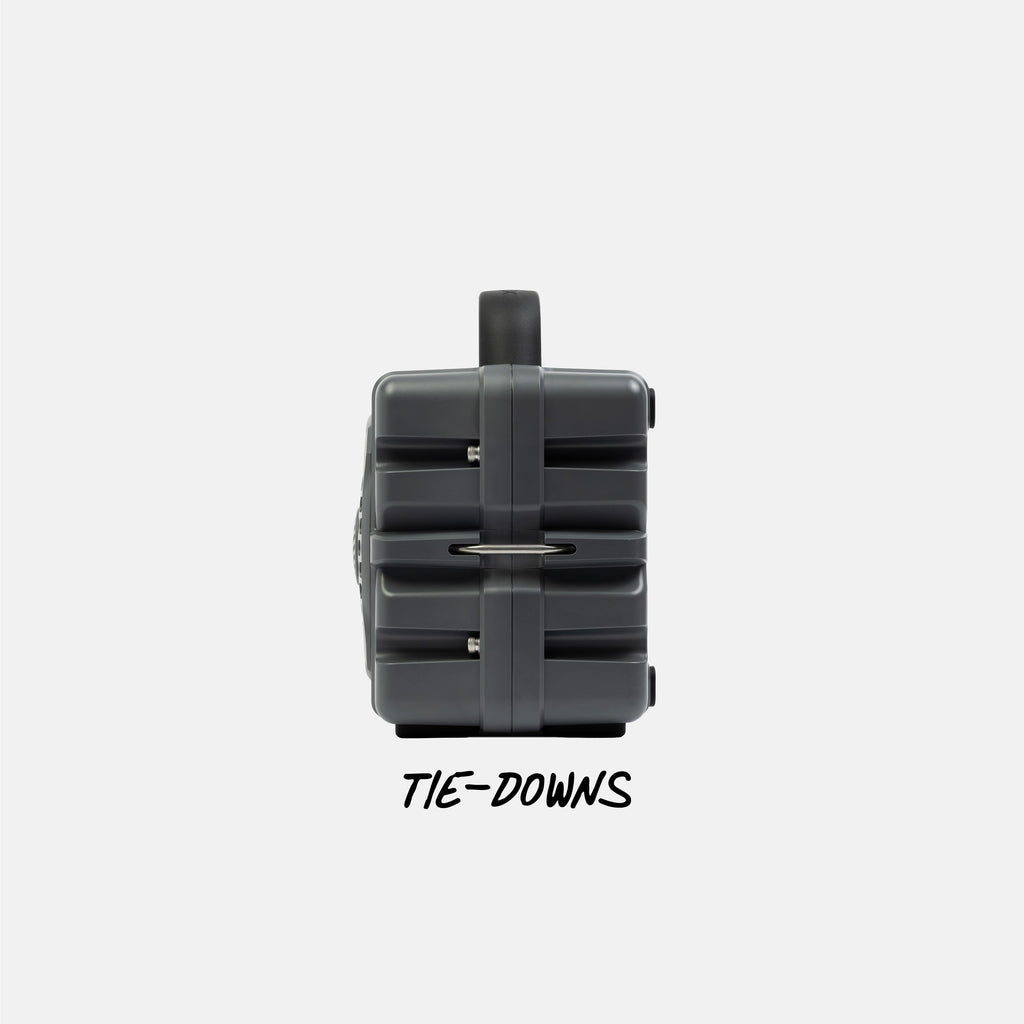 Gray speaker with a tie-down system on a white background with 'TIE-DOWNS' text. #base-color_gray