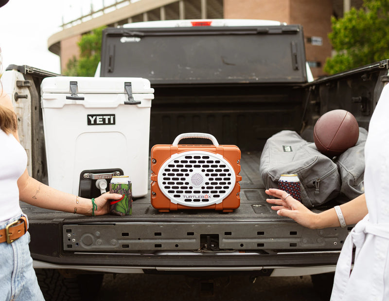 A lifestyle photo of a Burnt Orange & White Original Gen 3 speaker. #speaker-color_burnt-orange-white-gameday-series