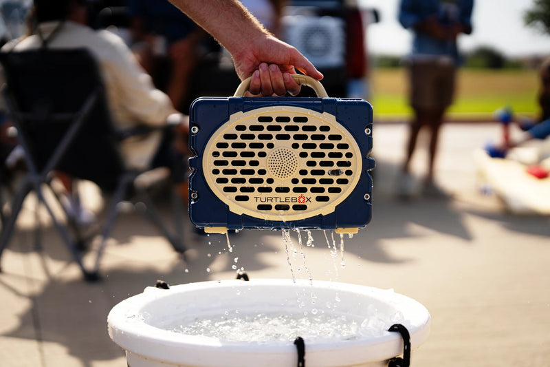A lifestyle photo of a Navy & Gold Original Gen 3 speaker. #speaker-color_navy-gold-gameday-series