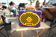 A lifestyle photo of a Purple & Gold Original Gen 3 speaker. #speaker-color_purple-gold-gameday-series