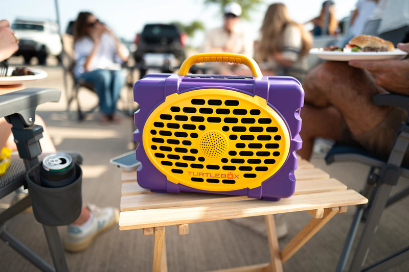 A lifestyle photo of a Purple & Gold Original Gen 3 speaker. #speaker-color_purple-gold-gameday-series