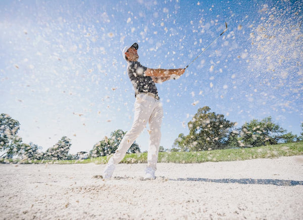 Scottie Scheffler playing golf on a sunny day with trees in the background